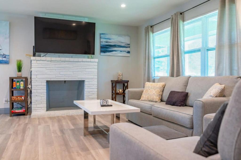 a living room with a couch and a fireplace at Beachtown Getaway with Tiki Hut in Pompano Beach