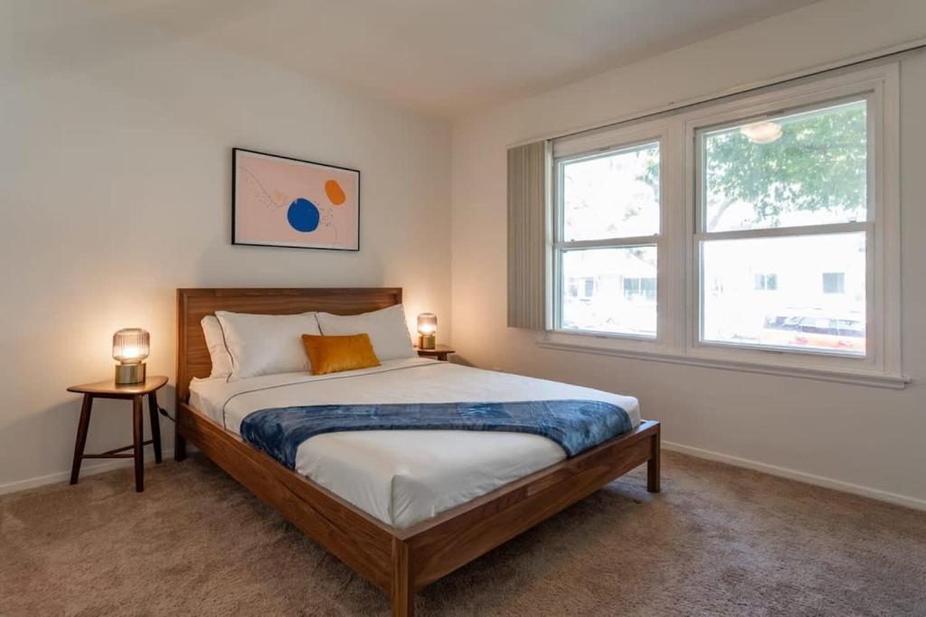 a bedroom with a large bed with two windows at Fast Wifi Luxury 1br Prime Location Huge Bed in Los Angeles