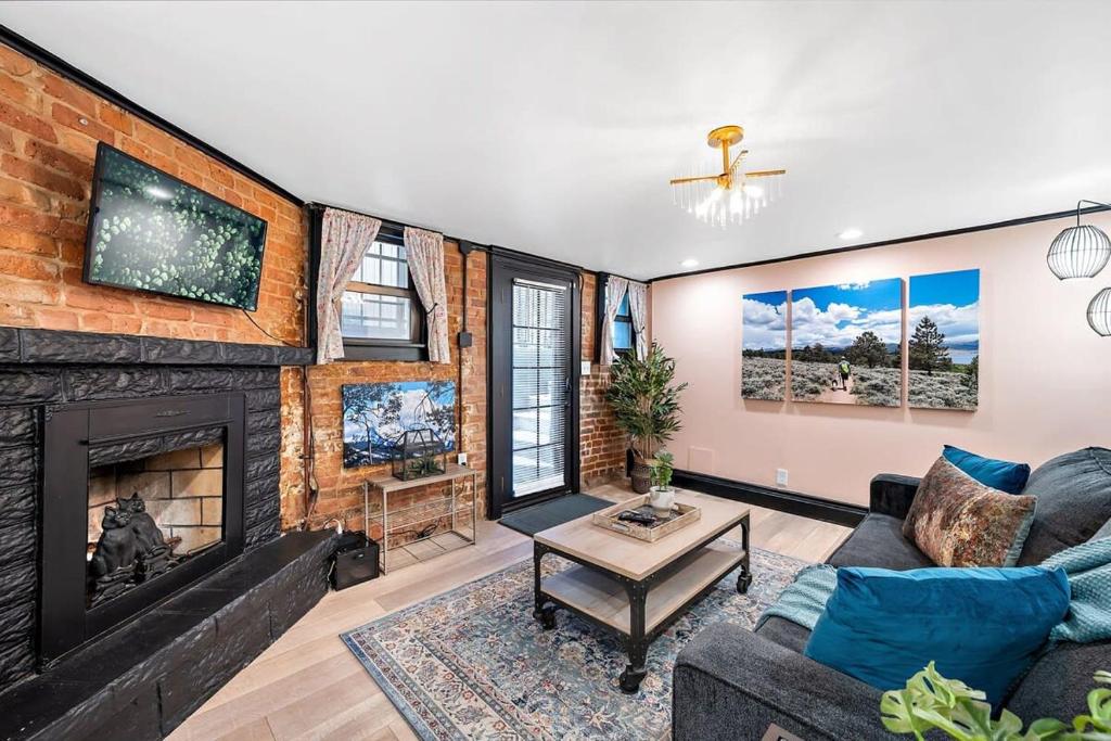 a living room with a fireplace and a brick wall at Charming & Updated Garden Level in Heart of Denver in Denver