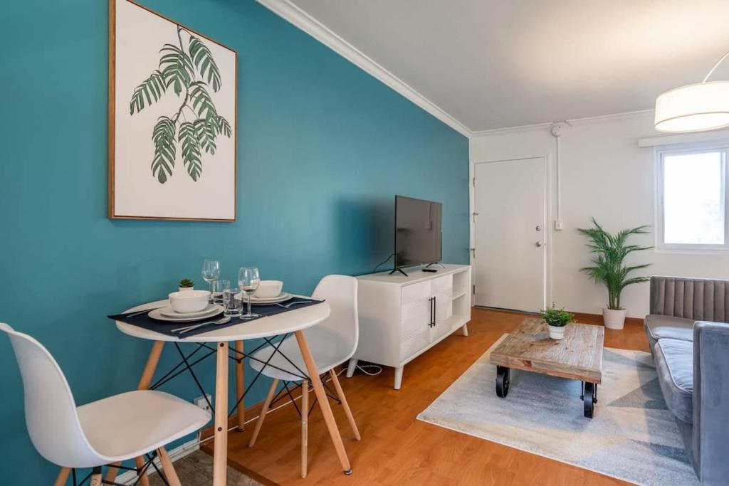 a living room with a table and a blue wall at Furnished Natural Zen Jungle Studio by LAX w Desk in Los Angeles