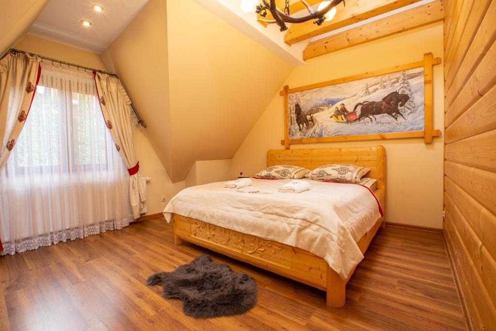 Un pat sau paturi într-o cameră la Poronin Mountain Apartments