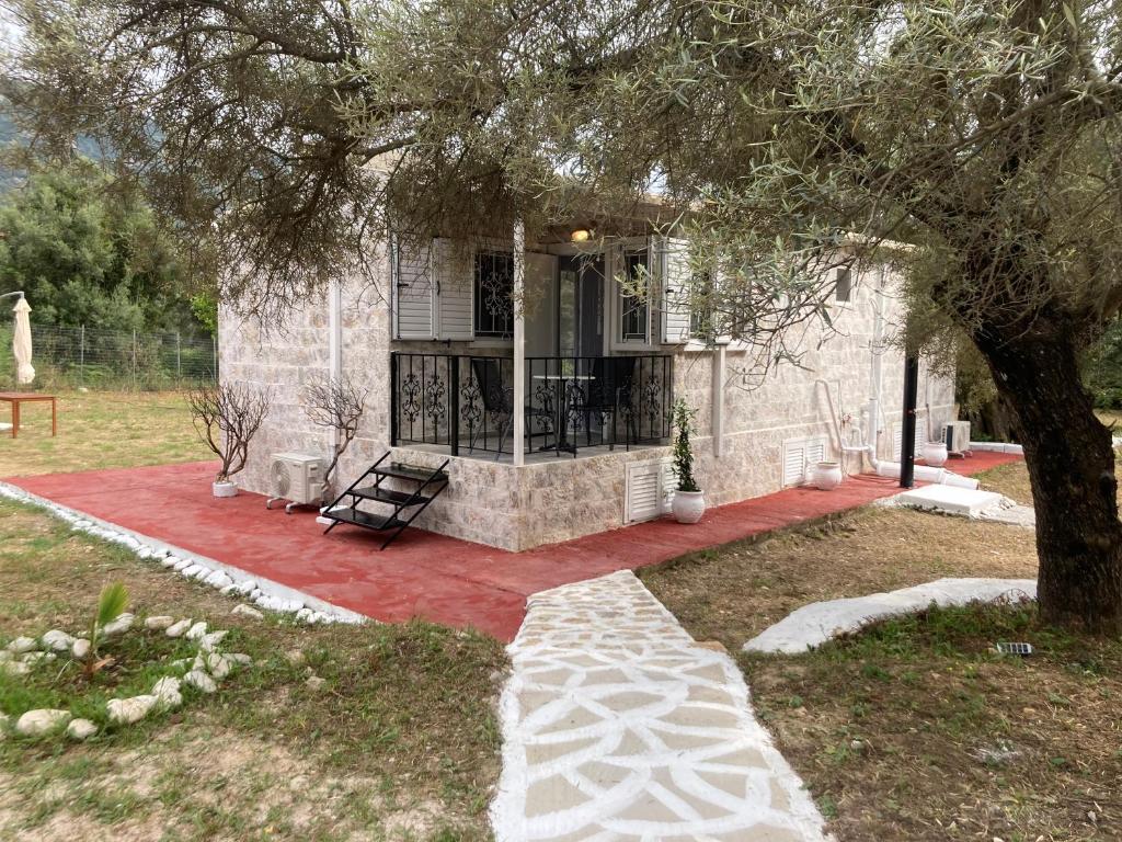 a house with a tree and a bench in a yard at Helios Beach House in Mikros Gialos