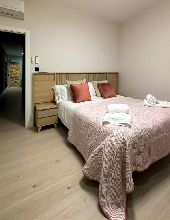 a bedroom with a large bed with red pillows at El Reloj De La Villa in Valdefuentes