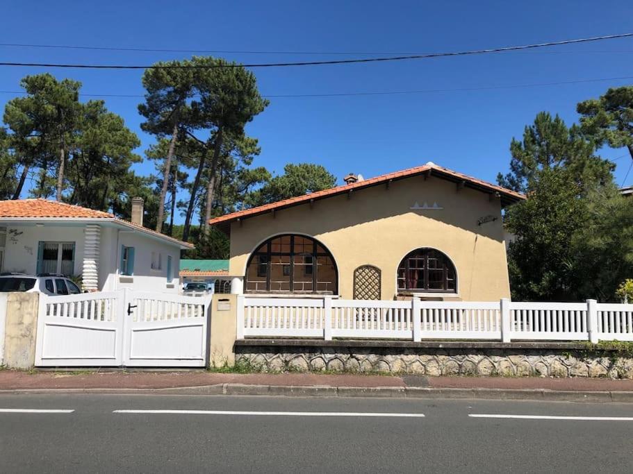 une clôture blanche devant une maison dans l'établissement La Chaumière, à La Tremblade