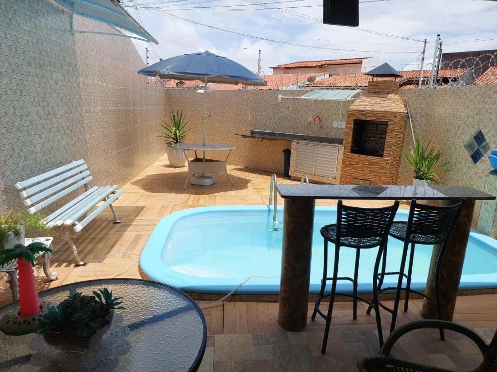 CASA próximo PRAIA para temporada في أراكاجو: فناء مع حوض استحمام ساخن وطاولة وكراسي