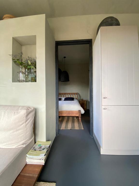 a bedroom with a bed and a door leading into a room at POLDER aan de Zeeuwse kust in Wemeldinge