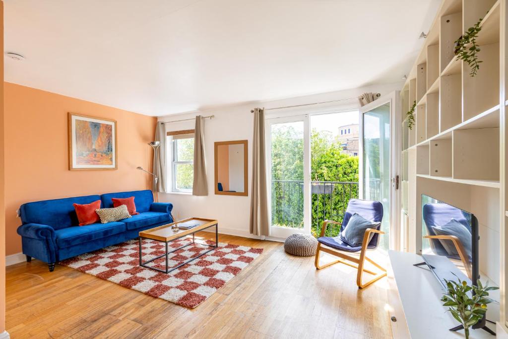 a living room with a blue couch and a table at Charming 2BR Flat, Holloway Road in London