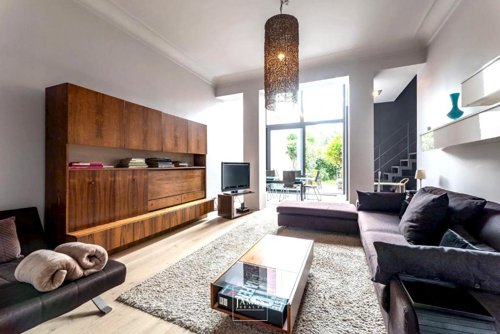 un soggiorno con divano e tavolo di 3 bedrooms apartement with enclosed garden and wifi at Bruxelles a Bruxelles