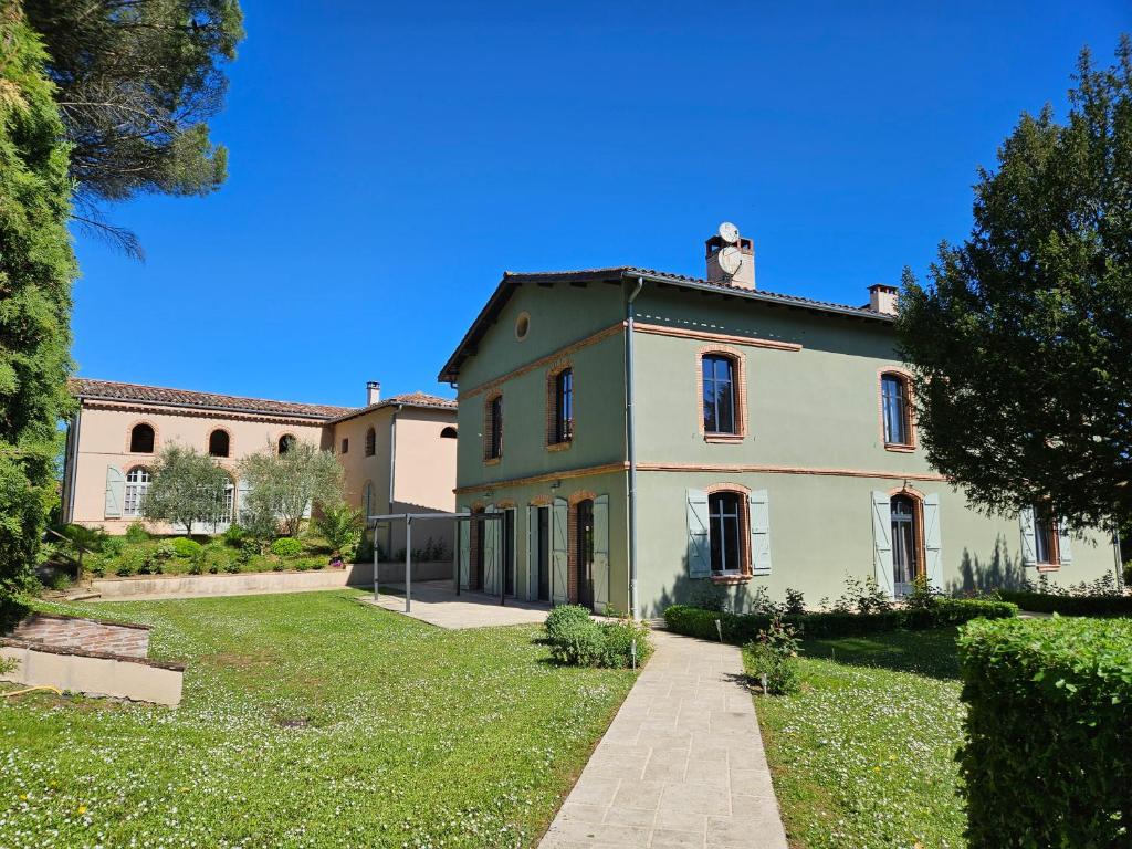 ein großes Haus mit einem Hof davor in der Unterkunft Domaine de Belcayre in Montauban