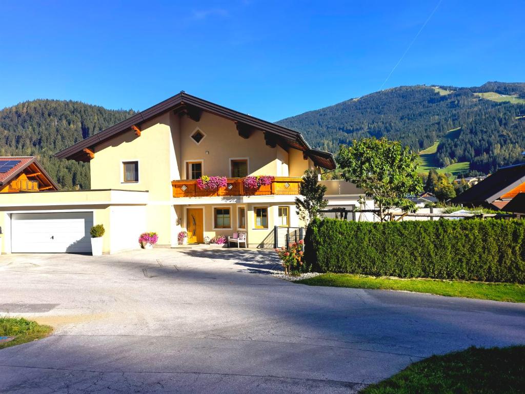 a white house with a fence and a driveway at Appartement Fritzenwallner in Wagrain