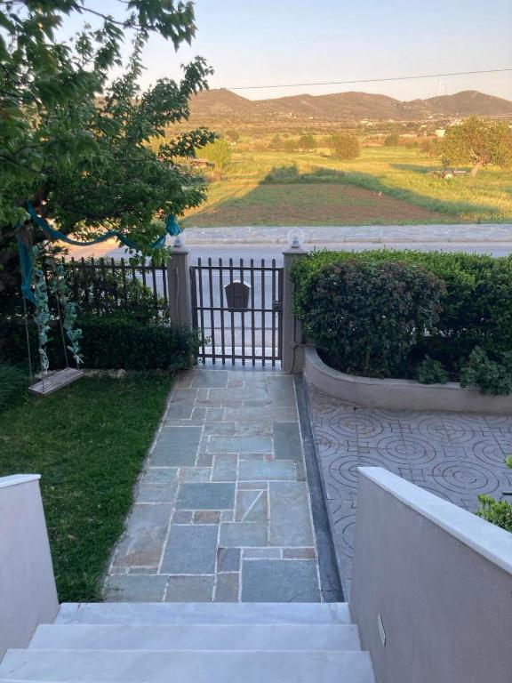 a garden with a gate and a stone walkway at Central Village House in Lépoura