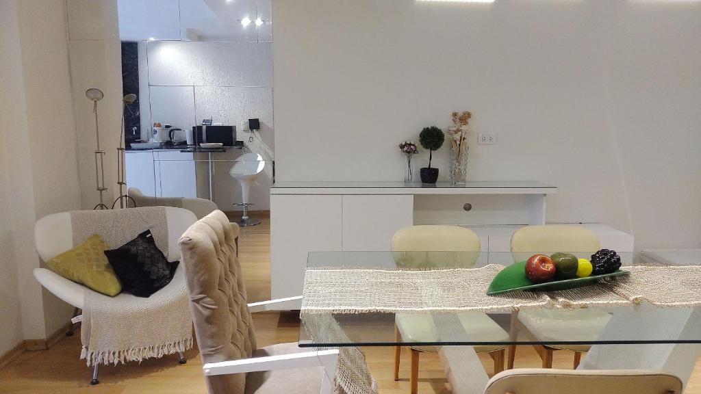 una sala da pranzo e una cucina con tavolo e sedie in vetro di Experimenta la automatizacion: Departamento inteligente a Santiago del Estero