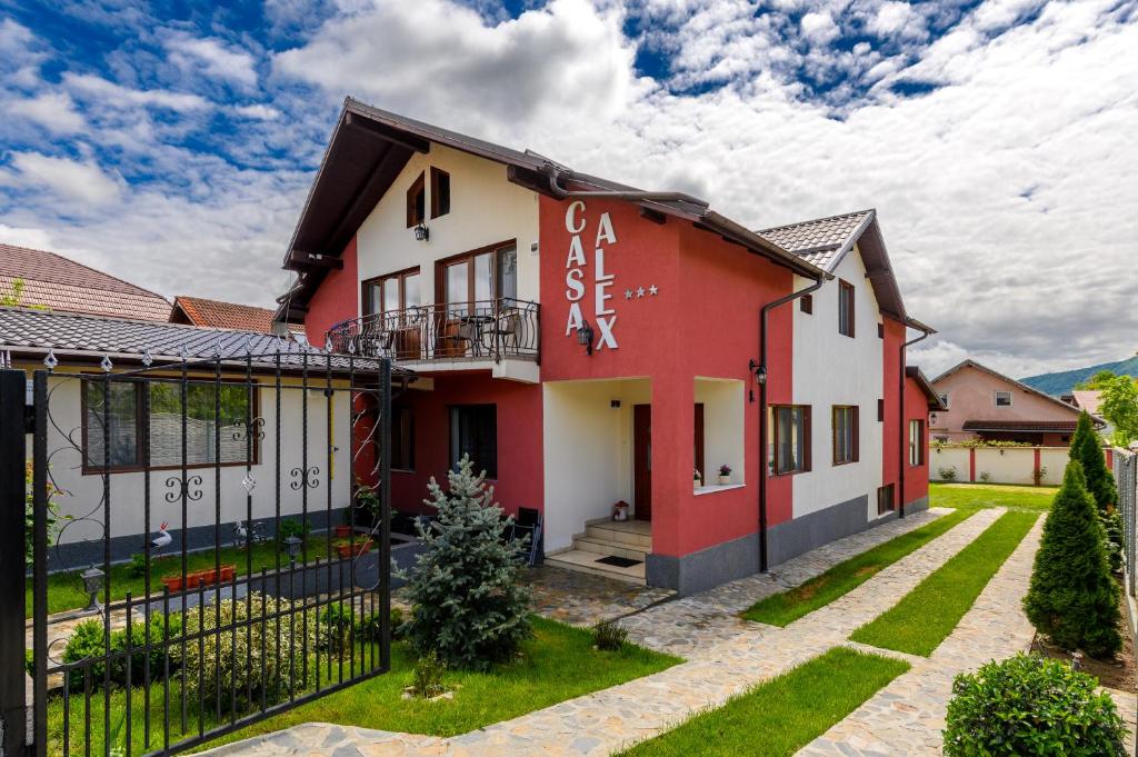 a house with red and white paint on it at Casa Alex Calimanesti in Călimăneşti