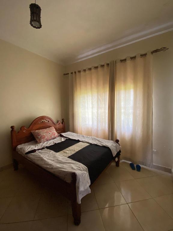 Cama en habitación con ventana en Unity Comfort Home, en Rukungiri