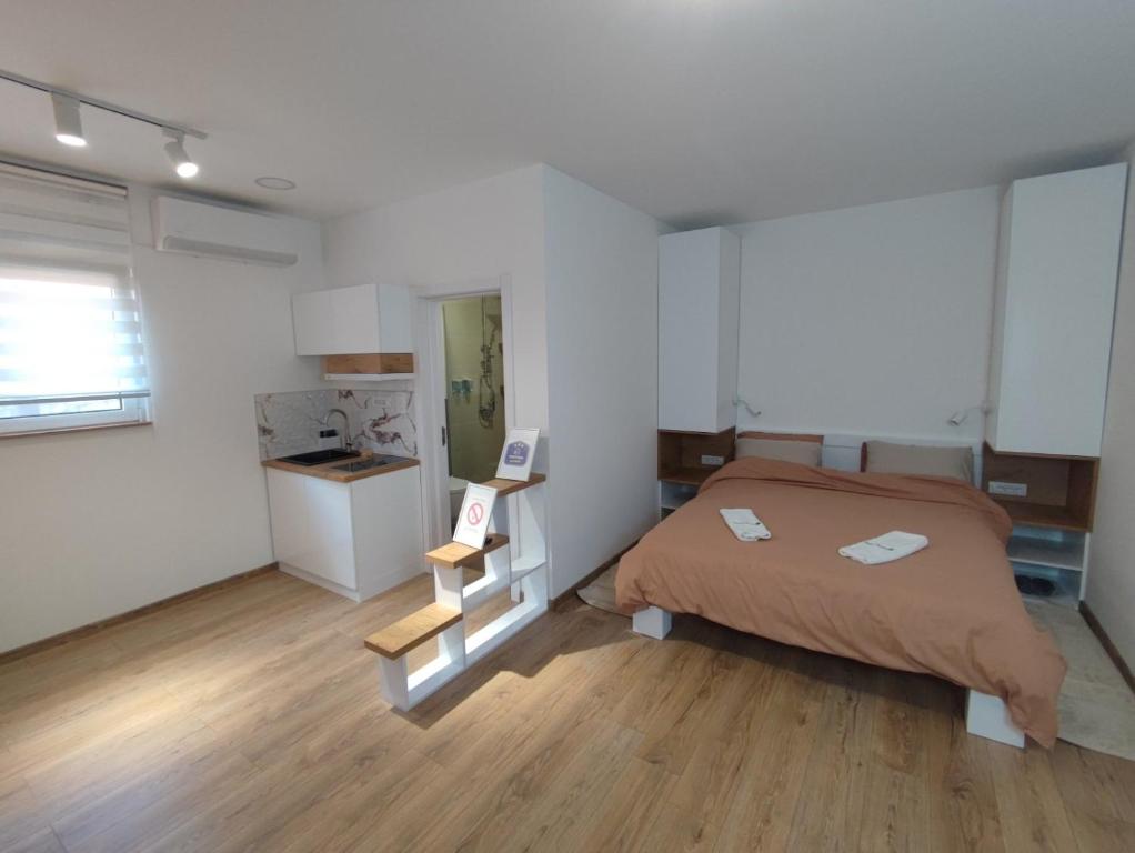 een kleine slaapkamer met een bed en een keuken bij Apartmani Happy House in Surčin