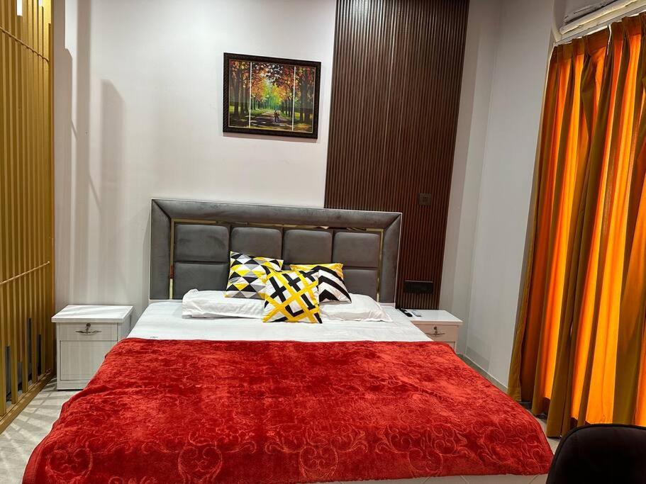 a bedroom with a large bed with a red blanket at Your homely studios in Ghaziabad