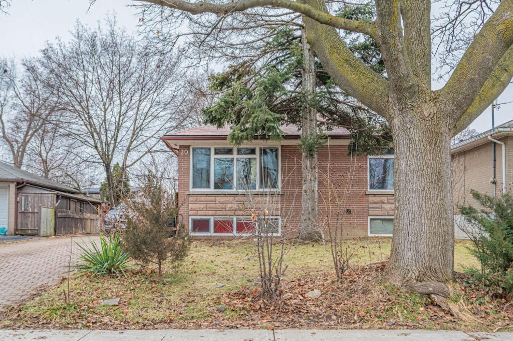 a brick house with a tree in the yard at Littlewood Properties in Toronto