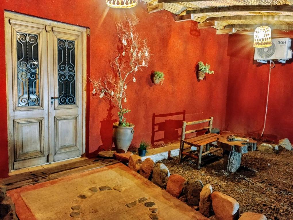 une chambre avec une porte, un banc et une table dans l'établissement La Genoveva Posada entre Viñedos, à Villa Unión
