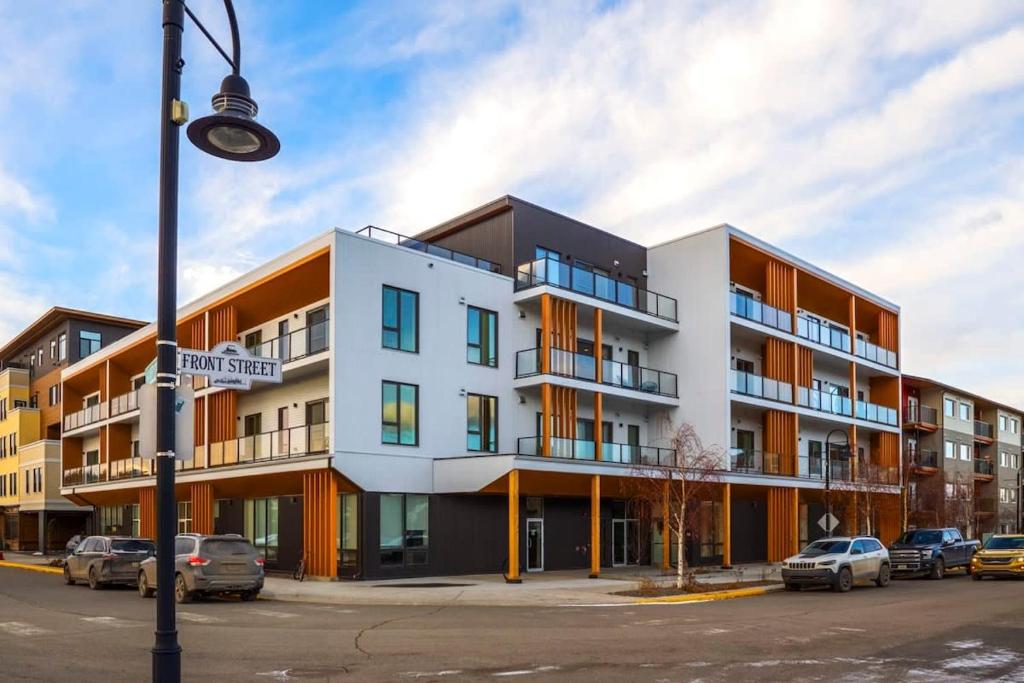 an apartment building with cars parked in a parking lot at NN - The Current 2 - Downtown 1-Bed 1-Bath in Whitehorse