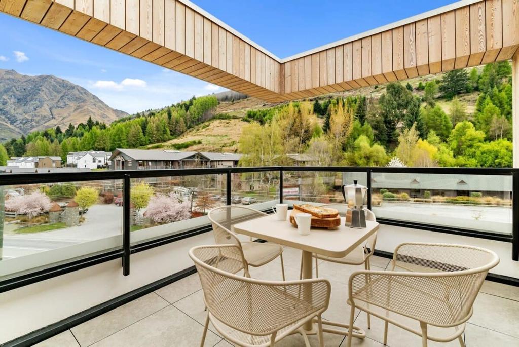 a dining room with a table and chairs on a balcony at The Terrace at La Residence du Parc in Queenstown