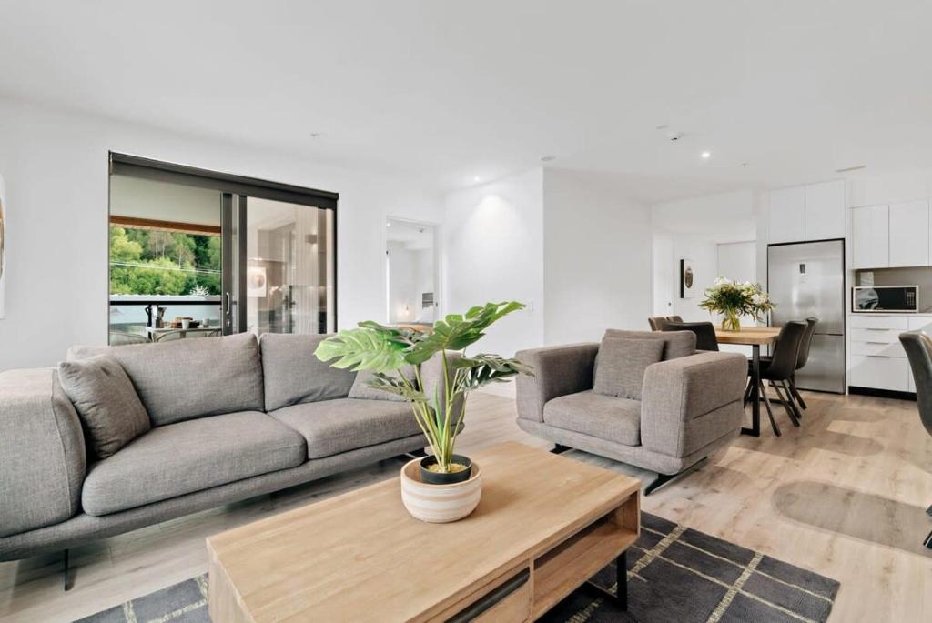 a living room with a couch and a table at Coronet Bliss - La Residence du Parc in Queenstown