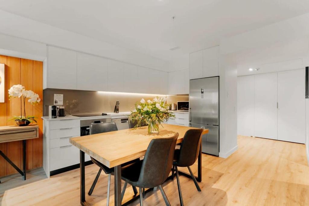 a kitchen with a wooden table and chairs at Residence Du Parc Apartment 8 in Queenstown