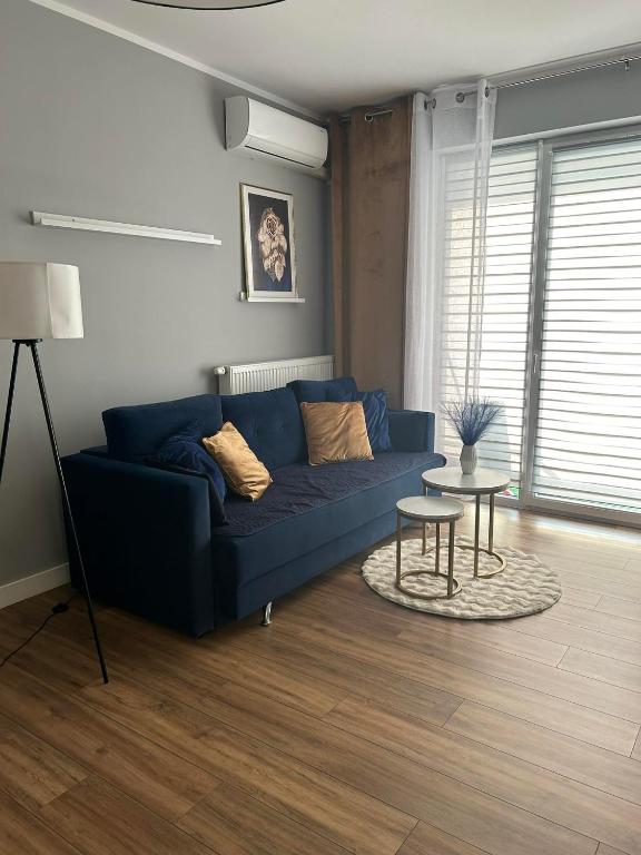 - un salon avec un canapé bleu et une table dans l'établissement Apartament blisko stacji kolejowej, à Mińsk Mazowiecki