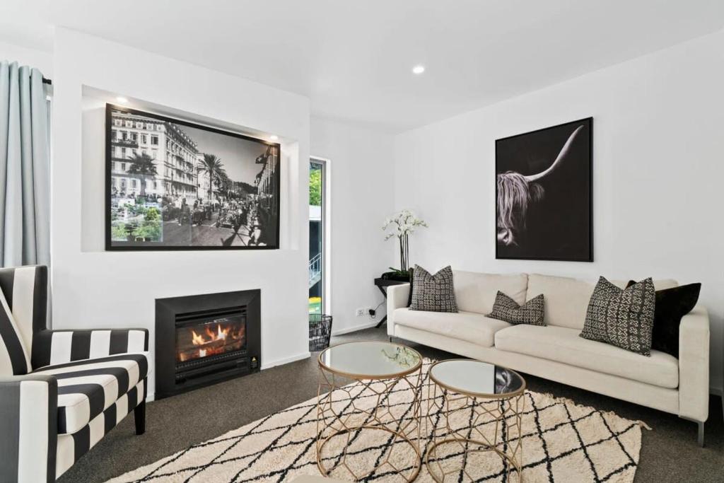 een woonkamer met een bank en een open haard bij Central Queenstown Luxury in Queenstown