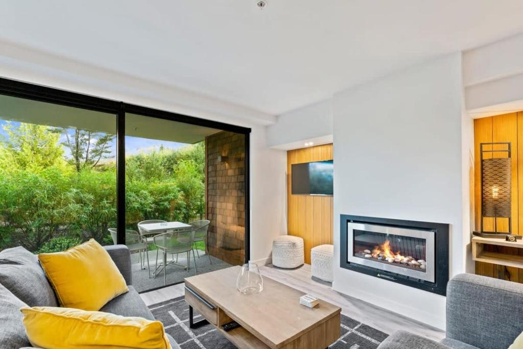 a living room with a couch and a fireplace at Cozy Coronet Peak Apartment at La Residence du Parc in Queenstown