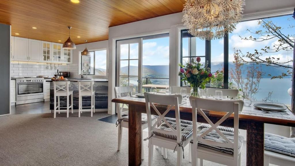 cocina con mesa y sillas y ventana grande en Greenstone Heights, en Queenstown