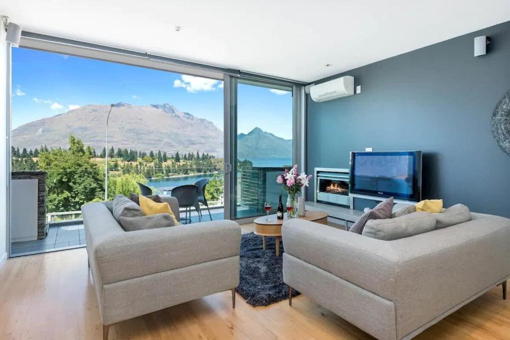 a living room with two couches and a large window at Luxury Lake View - 1 Bedroom in Queenstown
