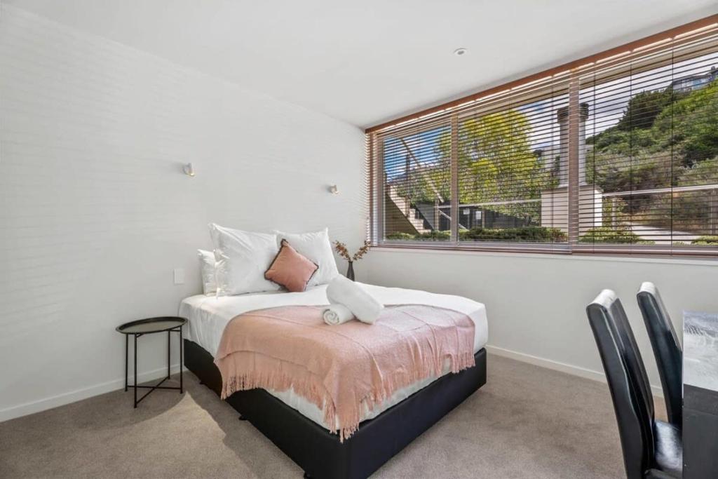 a bedroom with a bed and a large window at Tranquil Modern Studio in Queenstown