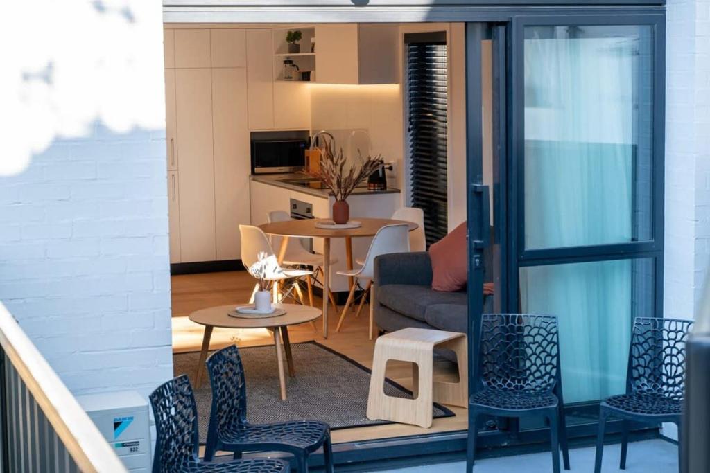 a balcony with a living room and a table and chairs at Albert Town Whare in Albert Town
