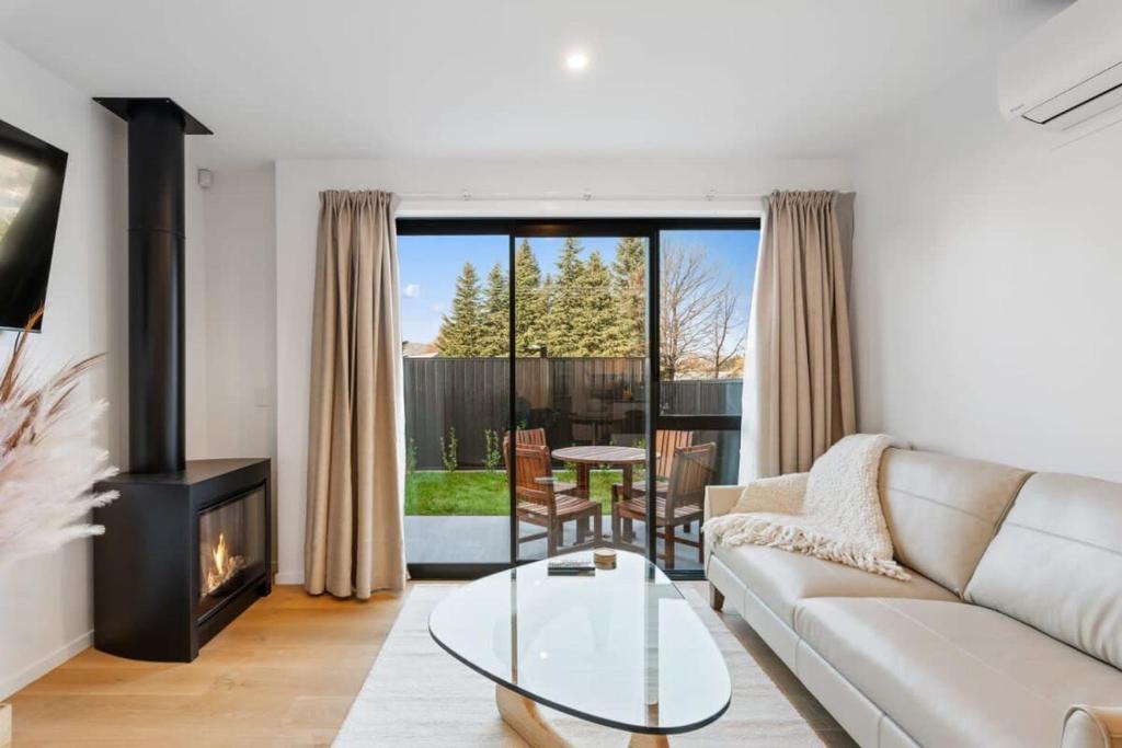 a living room with a couch and a fireplace at Wanaka Hararei in Albert Town