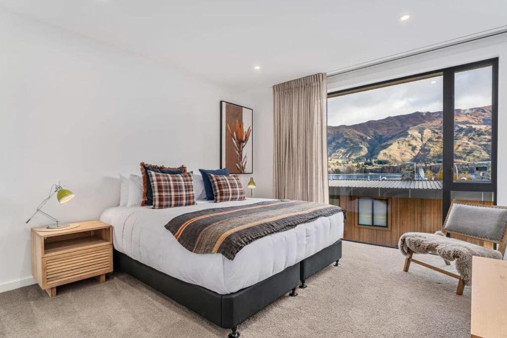 a bedroom with a bed and a large window at Lakeview Luxuy Vista Suite in Wanaka