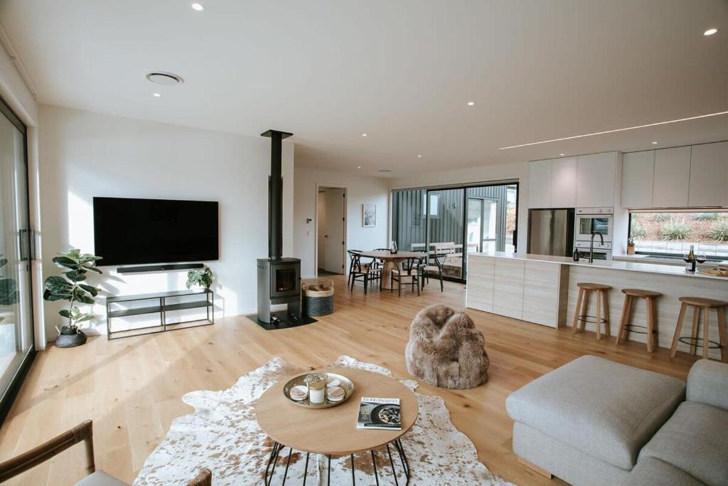 a living room with a couch and a table at Obelisk Dream with Spa in Wanaka