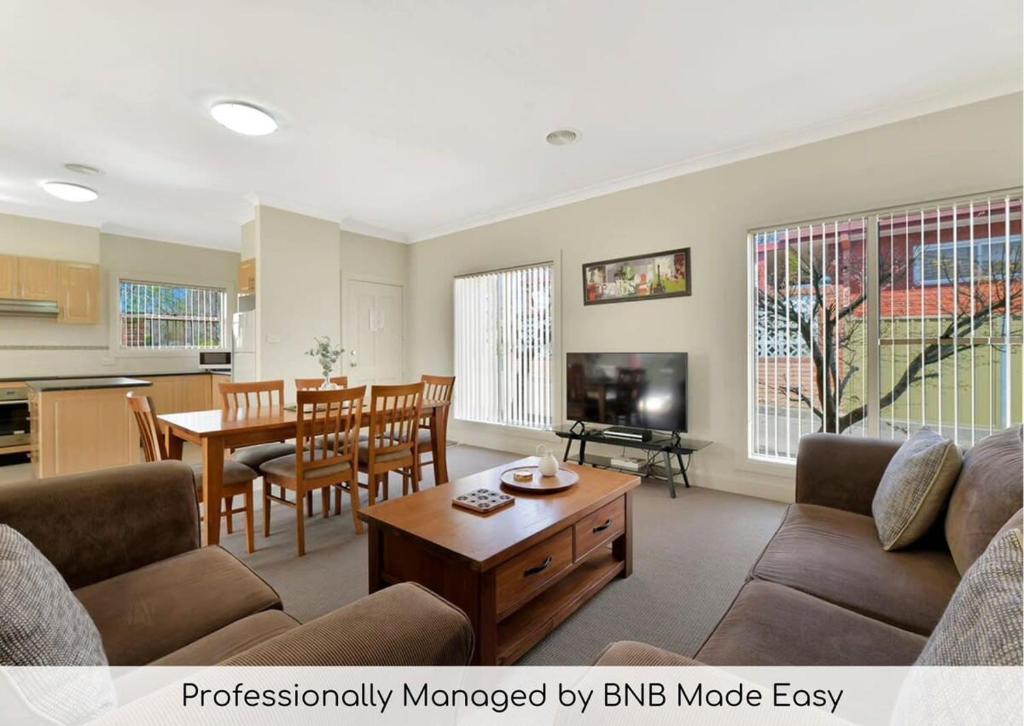 a living room with a couch and a table at Spacious 2 Bed, 2 Bath Villa, CBD Location in Orange