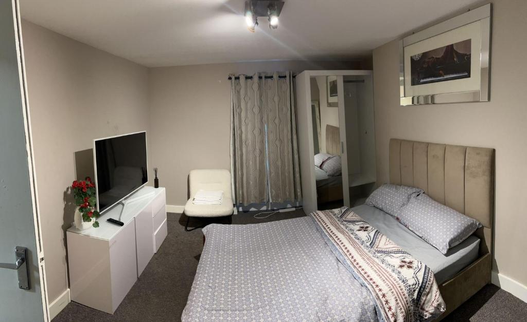 a bedroom with a bed and a flat screen tv at Clocktower Apartment in Kent
