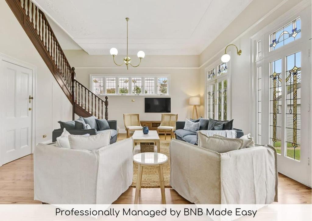 a living room with two couches and a tv at Kilarra House - Heritage Home on Byng St Sleeps 10 in Orange