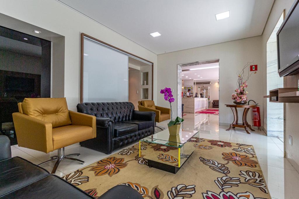 a living room with a couch and chairs and a table at Hotel Nacional Inn Araçatuba in Araçatuba