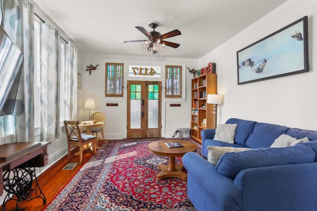 a living room with a blue couch and a table at Beautiful Historic Mid City Home in New Orleans