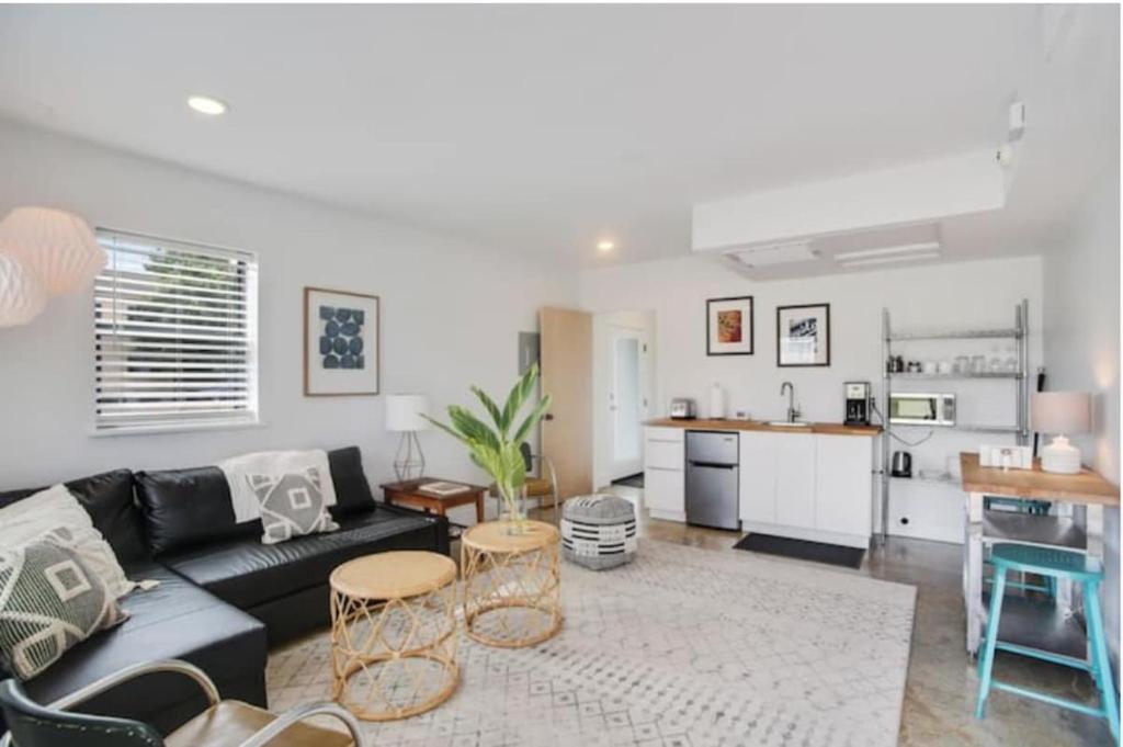 a living room with a black couch and a kitchen at River Breeze Quiet & Modern Black Pearl Apartment in New Orleans