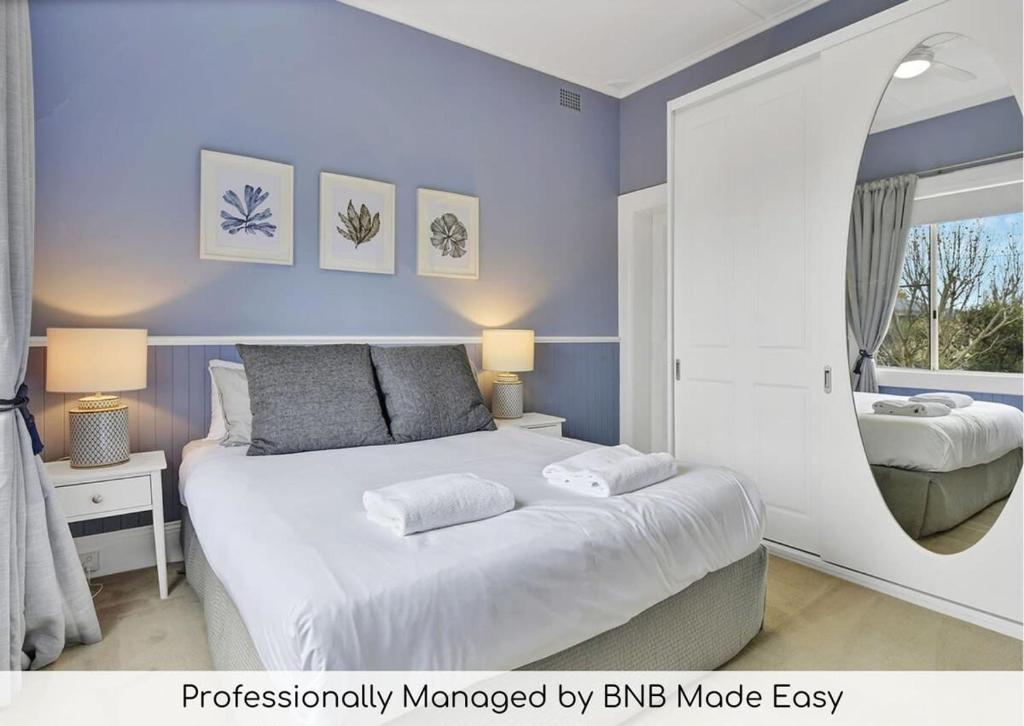 1 dormitorio con 1 cama grande y paredes azules en Kinross Cottage Close to CBD Comfy & Convenient en Orange