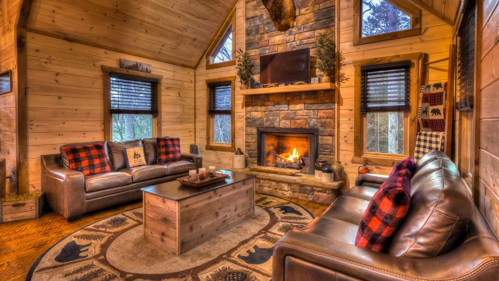 a living room with leather furniture and a fireplace at Immeasurably More in Mineral Bluff