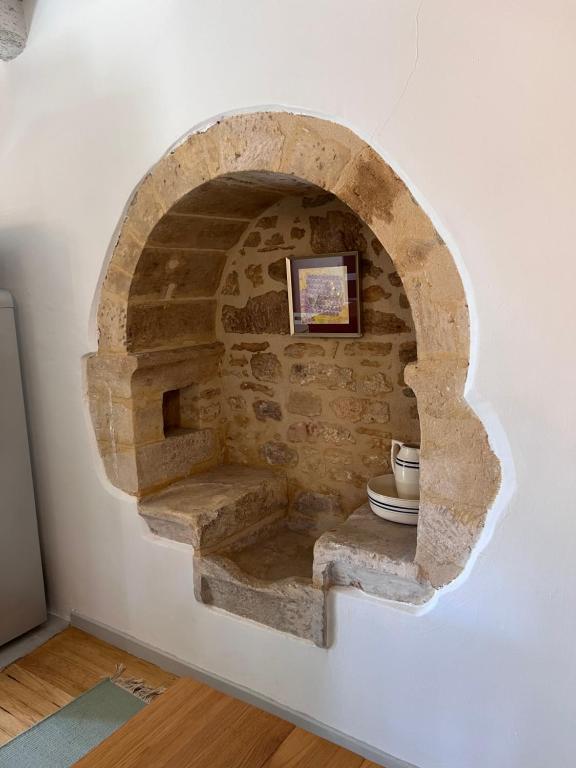 einen steinernen Torbogen mit einem WC an einer Wand in der Unterkunft Appartement de charme in Vitrac