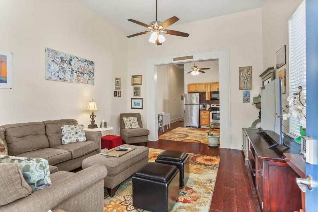 a living room with a couch and a ceiling fan at Art Filled Sanctuary in the Heart Of Mid City in New Orleans