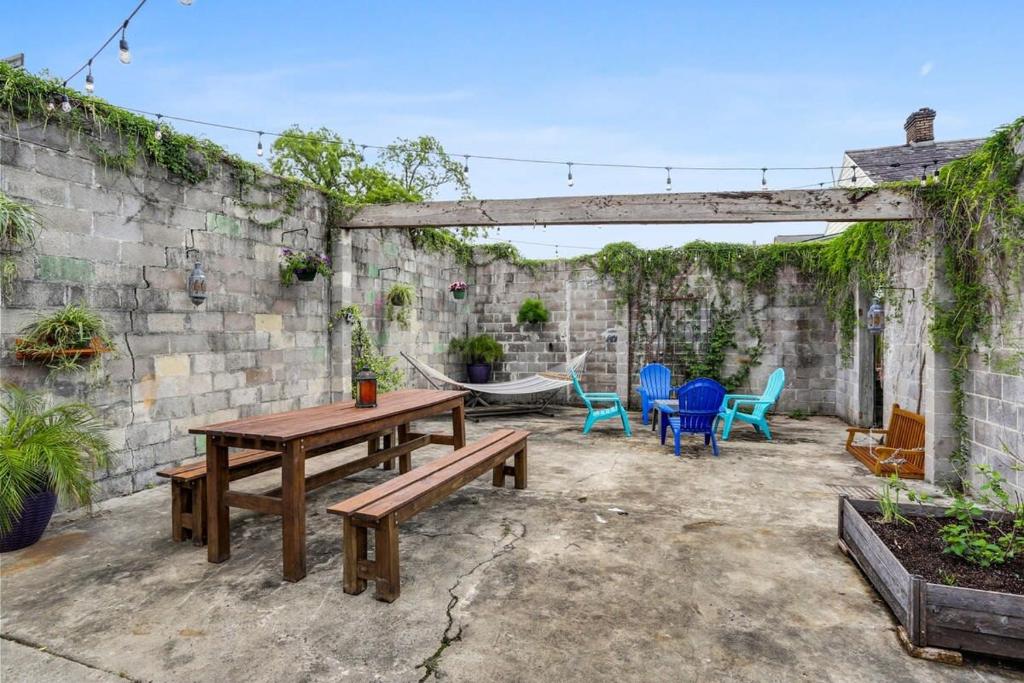 a patio with a wooden table and chairs at Urban 3 bedroom Local Art Filled Frenchman Oasis in New Orleans