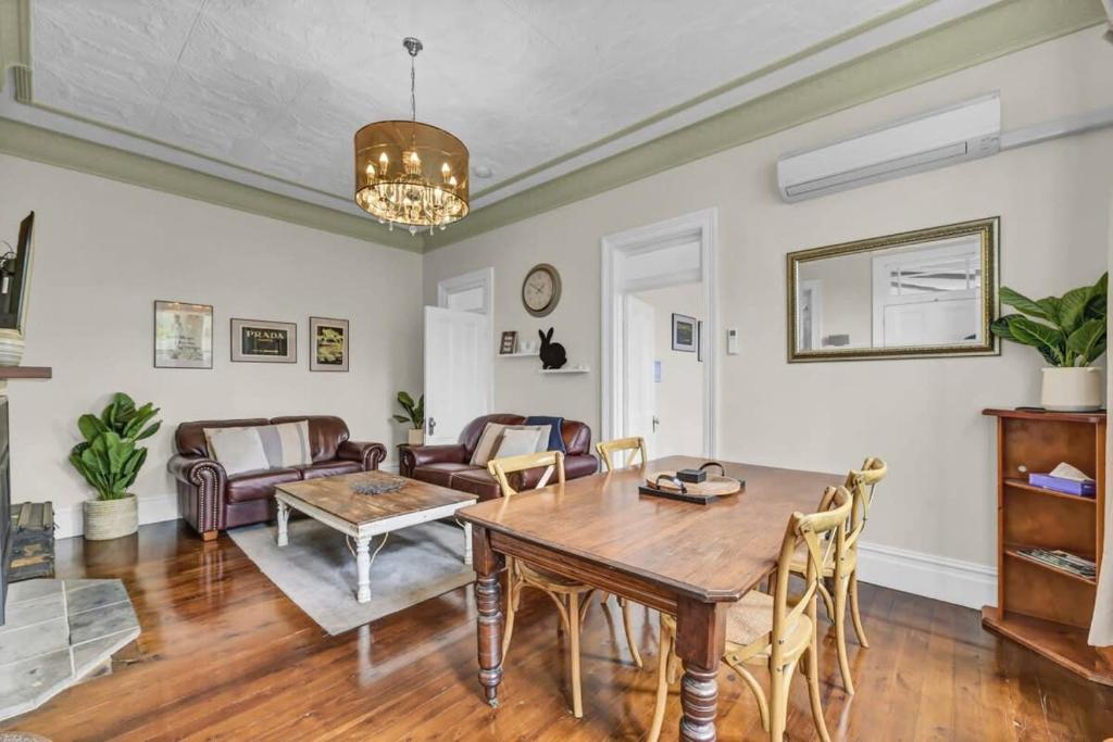 a living room with a table and a couch at Edwina Suite II - Fireplace, Elegant Heritage Home in Orange
