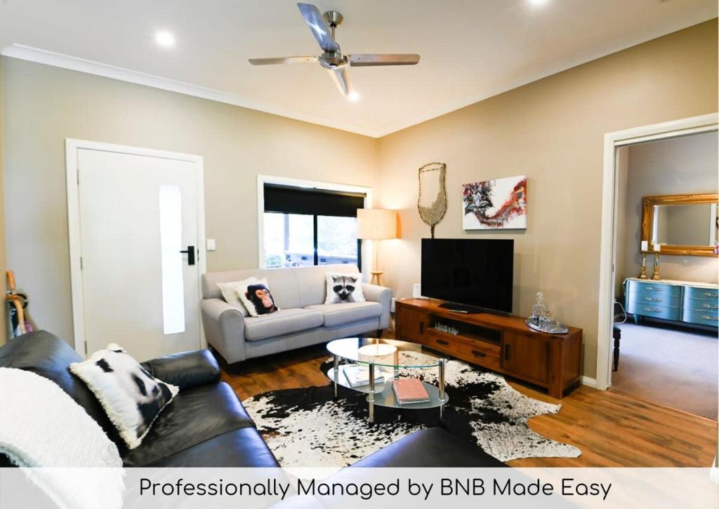 a living room with a couch and a tv at Sterling House Spacious Deck BBQ Pet Friendly in Dubbo
