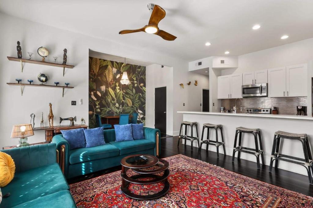 a living room with a blue couch and a kitchen at Stylish 2-Bedroom Apartment in Garden District in New Orleans